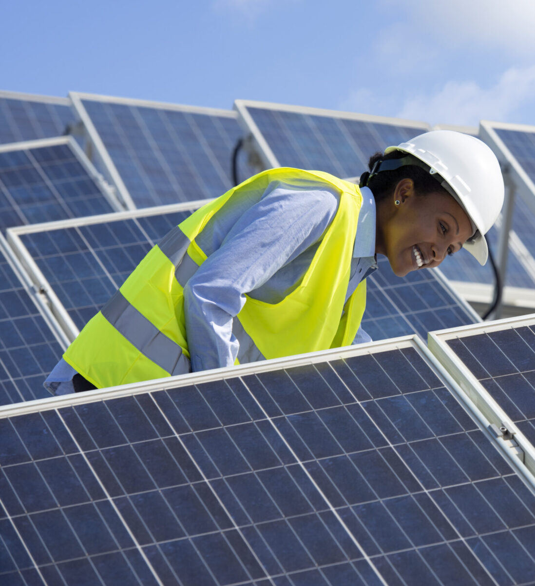 Electrical engineer woman checking solar photovoltaic panels on the roof of a solar farm.